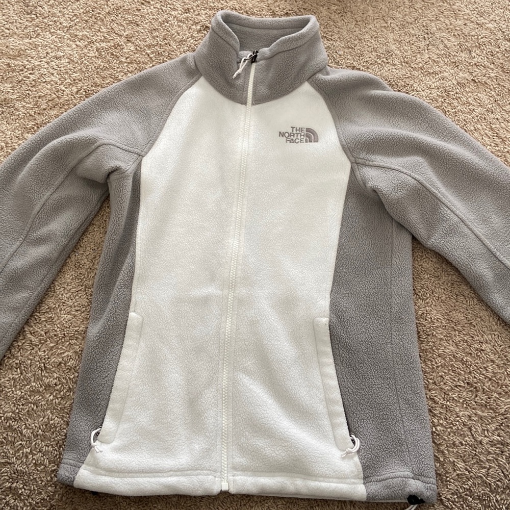 This is a North Face zip up sweatshirt in a women’s XS. It is white and grey.